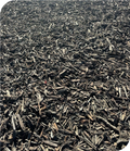 Dark brown wood chips or mulch spread across the ground in a textured, chopped organic material.